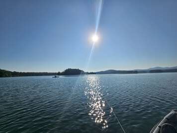 Lake Blue Ridge, GA reflects the bright sunlight, with a...