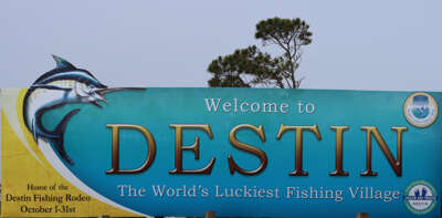 A colorful welcome sign greets visitors to Destin, proclaiming...