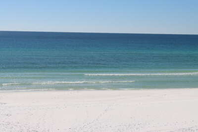 Clear blue waters gently lap against a pristine white sand...