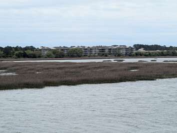 A cluster of buildings is visible across a peaceful body of...