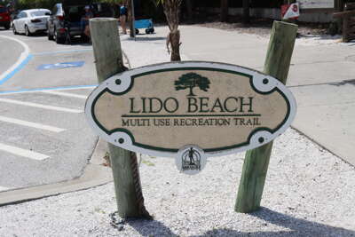A sign for Lido Beach and its multi-use recreation trail stands...