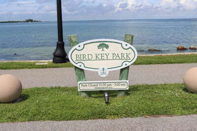 A wooden sign for Bird Key Park is prominently displayed in...