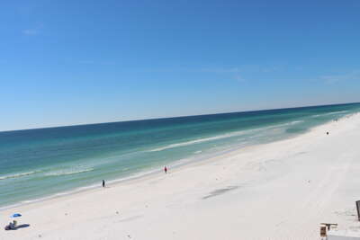 A clear day on a pristine beach, with a few visitors scattered...