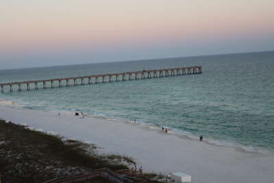 Navarre Beach, FL at twilight with people near the water's...