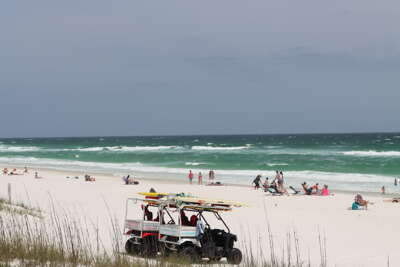 Navarre Beach, FL with visitors enjoying the sun and sand,...