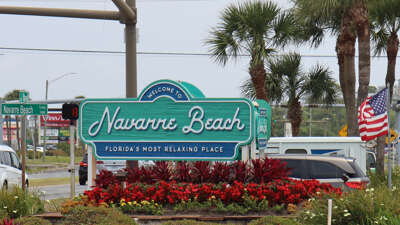A welcoming sign for Navarre Beach, labeled as "Florida's Most...