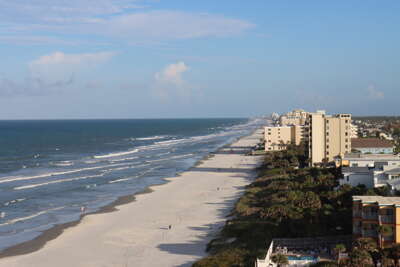 A sweeping view of New Smyrna Beach, FL stretching alongside a...