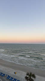 A view at dawn captures the ocean waves gently meeting the...