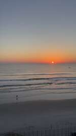 A serene beach at sunrise with gentle waves lapping against the...