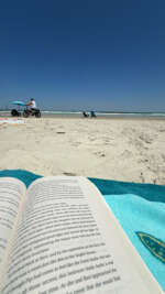 A beach scene captured from the perspective of someone reading...