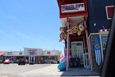 Shops adorned with beach-themed decorations, including large...