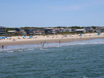 A sandy beach stretches along the shoreline with calm ocean...