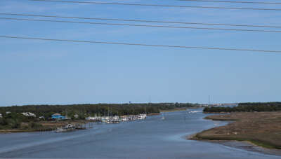 A serene river flows gently through a landscape with boats...