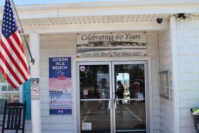 The entrance to the pier displays a sign celebrating its 60th...