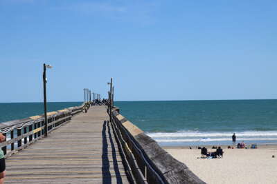 Ocean Isle Beach pier stretches out over the ocean, with people...