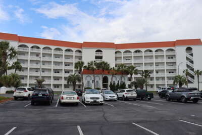 A multi-storey resort condo rentals with balconies, flanked by...