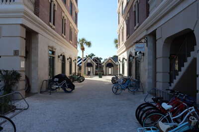Bicycles are parked along a downtown street flanked by large...