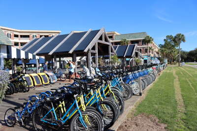 Rows of bicycles for rent line a pathway in front of vacation...