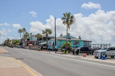 A coastal street lined with various buildings overlooks a...