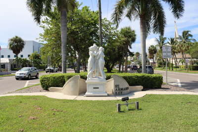 Palm trees frame a statue of Alexander Bell, located in a...