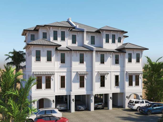 Front exterior view of two connected white beach houses with metal roofs, multiple windows, and covered parking spaces.