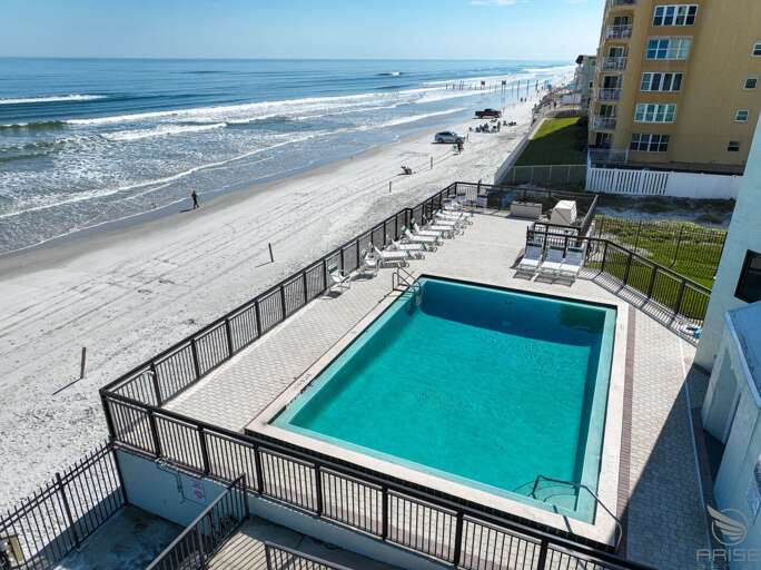 Ocean Trillium 303 (OT303) - New Smyrna Beach - Condo complex offers an oceanfront pool, an outside shower, elevator, credit card operated washer/dryer on-site, and private beach access