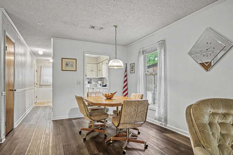 Picture yourself gathering around this welcoming dining table, bathed in natural light from the window. The space flows effortlessly into the kitchen, perfect for your vacation meals.