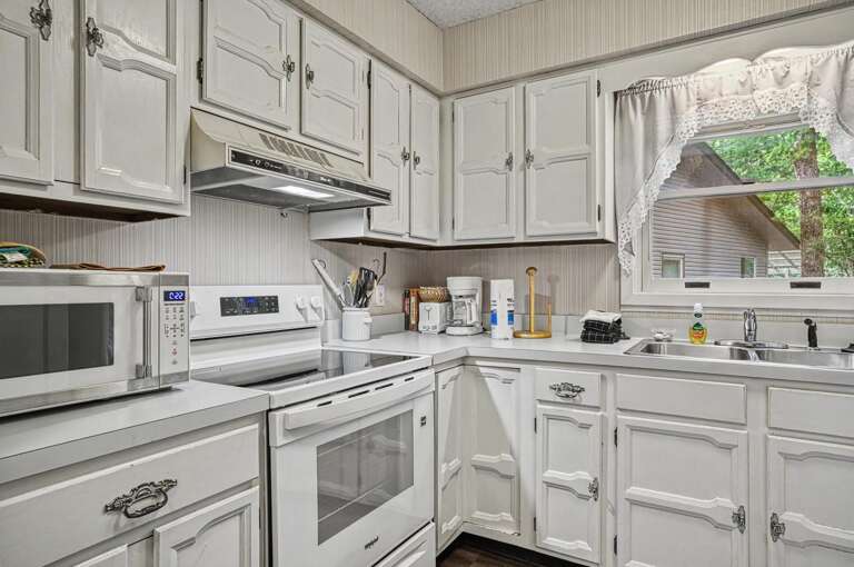 Step into a bright, fully equipped kitchen where you'll find everything you need to whip up meals during your stayâfrom the microwave and stove to ample counter space and charming cabinet storage.