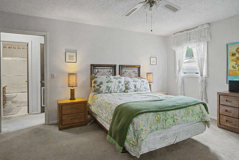 Your peaceful bedroom features a cozy bed with tropical-inspired linens, soft lighting, and gentle natural lightâperfect for unwinding after a day of adventure.