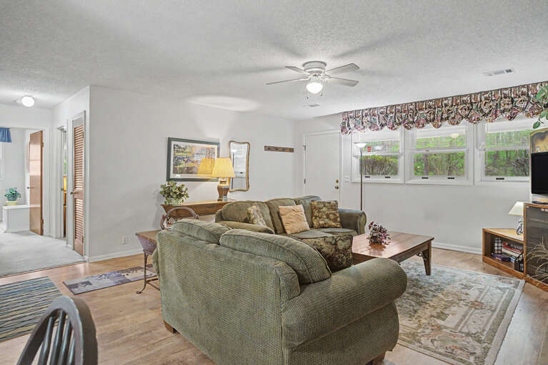 Settle into this bright, comfortable living room where natural light pours through large windows and plush seating invites you to unwind after a day of adventure.
