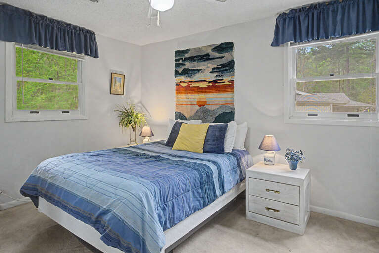Soft morning light filters through the windows, illuminating your peaceful retreat with calming blue tones and artistic touches that invite restful nights.