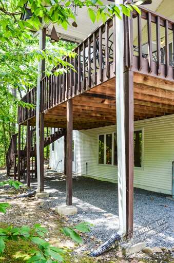 This peaceful retreat sits nestled among the trees, with an elevated deck and charming wooden accents that blend seamlessly into the surrounding natural landscape.