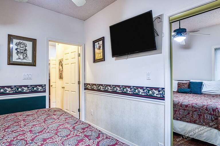Your bedroom features a wall-mounted TV for easy viewing from bed, a ceiling fan to keep you comfortable, and access to the adjacent room through a connecting door.
