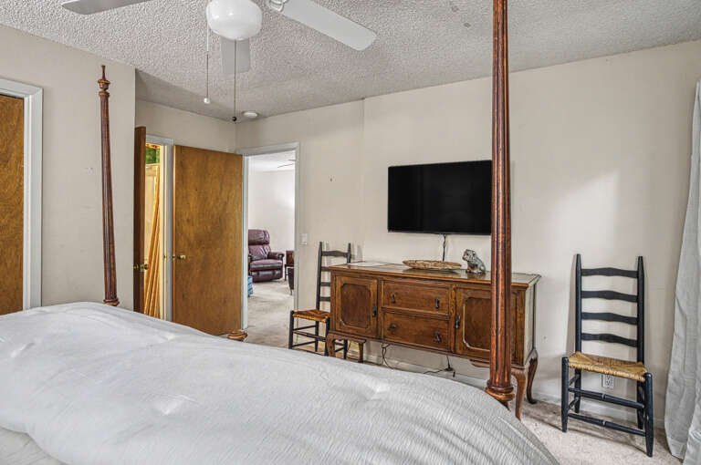 Settle into your spacious bedroom, where classic wood furnishings and a ceiling fan create a comfortable, home-away-from-home retreat perfect for unwinding after your day's adventures.