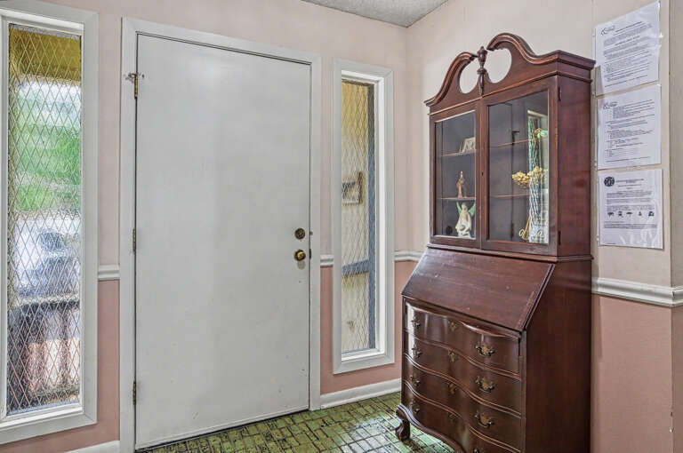 Step into a warm entryway where classic charm meets practical comfort, featuring elegant glass-paned windows that brighten your arrival.