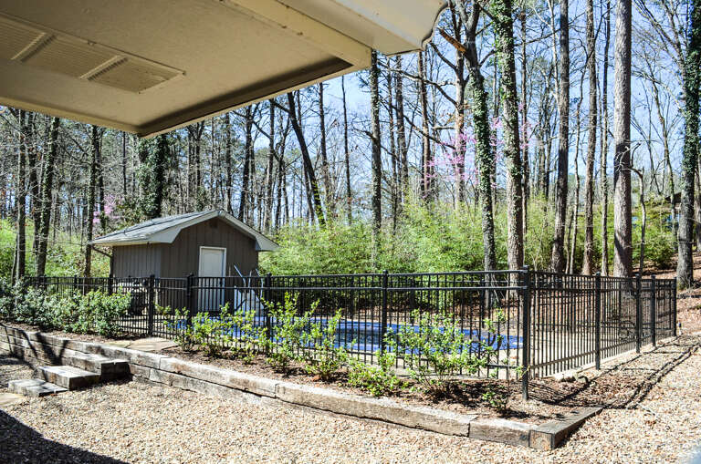 Private pool surrounded by towering trees creates your secluded forest retreat with covered seating area.