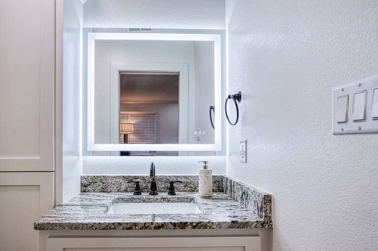Freshen up in your elegant bathroom featuring granite countertops, LED mirror, and premium fixtures for a luxurious daily routine.