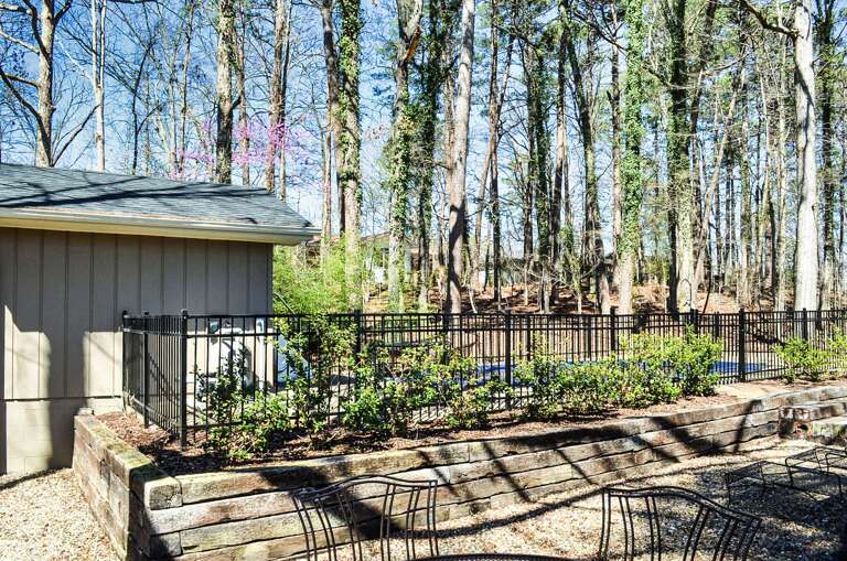 Property nestled among mature trees with thoughtfully landscaped grounds and natural woodland surroundings.