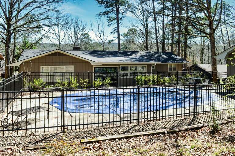 A lovely ranch-style home with private swimming pool set among towering trees in a peaceful wooded neighborhood.