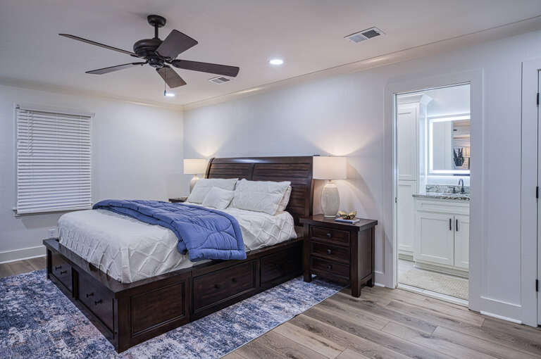 Your spacious master suite features rich wood furnishings, soft lighting, and an ensuite bathroom for ultimate comfort and privacy.