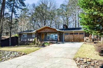 Charming ranch-style home nestled among mature trees with convenient parking and peaceful woodland surroundings.