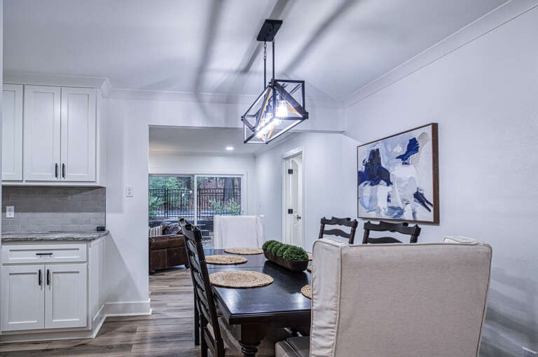 Gather around your elegant dining table beneath the striking geometric chandelier for memorable meals together.
