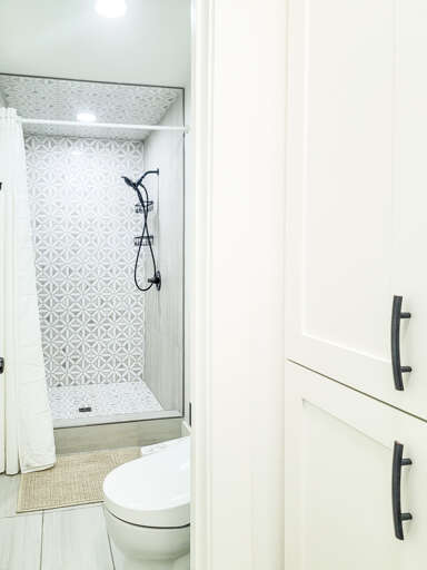 Your private bathroom features a stunning geometric-tiled shower and modern fixtures for a refreshing start to each day.