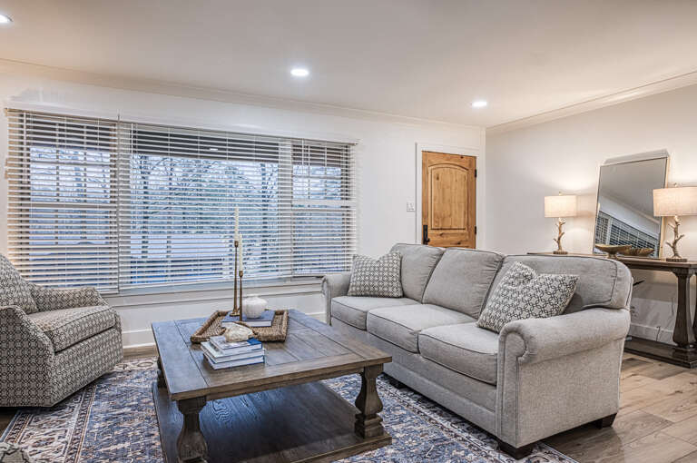 Sink into plush sofas in your stylish living room, where natural light streams through wide windows and thoughtful touches create the perfect retreat.