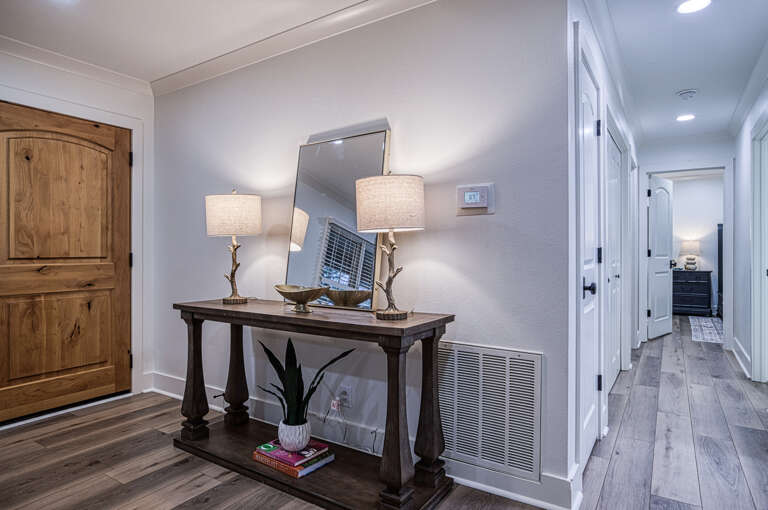 Step into your stylish entryway where elegant furnishings and warm lighting create an immediate sense of home.