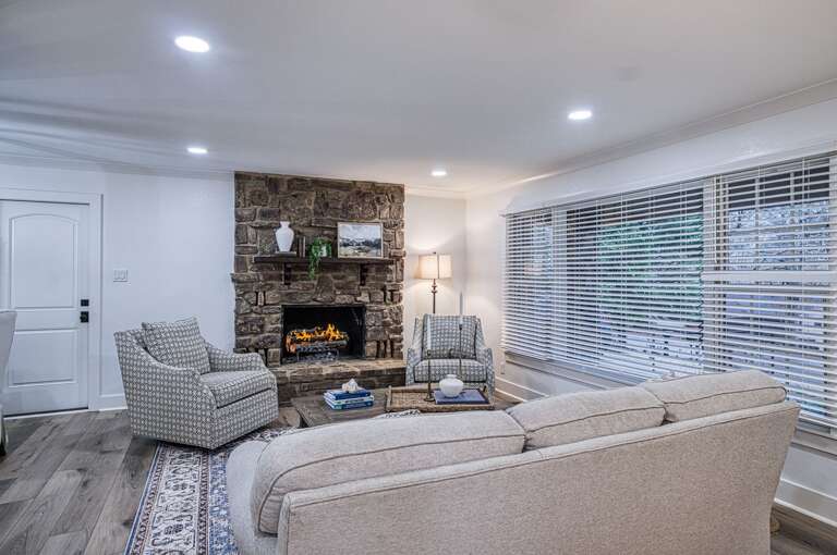 Unwind in your elegant living room where a crackling stone fireplace creates the perfect ambiance for cozy evenings together.