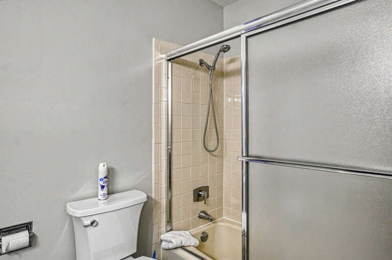 Refresh with a clean, modern bathroom featuring a pristine tiled shower-tub combo and all the essentials for your comfort.