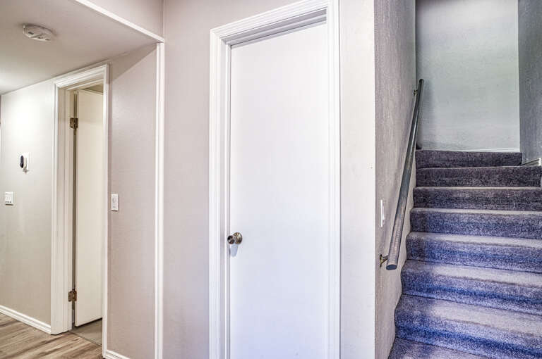 Fresh neutral tones and modern finishes create a welcoming atmosphere as you enter your vacation home, with easy stairway access to additional living spaces.