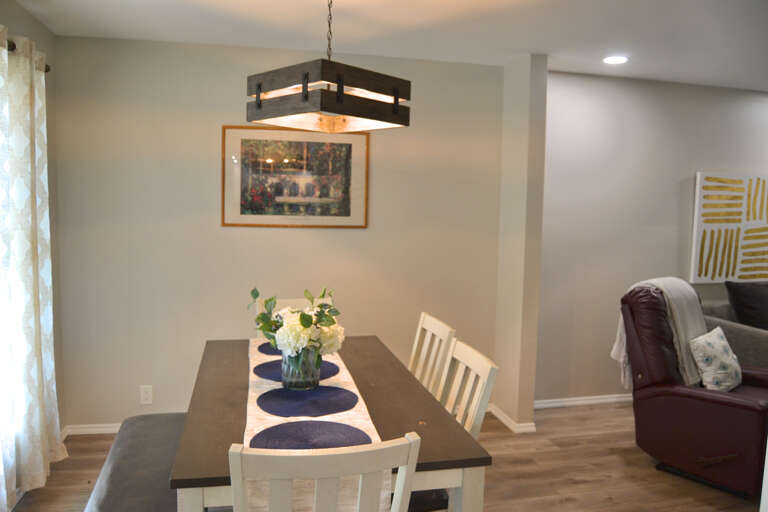 Gather around your dining table under warm pendant lighting, with fresh flowers and tasteful art creating a welcoming spot for meals and conversation.