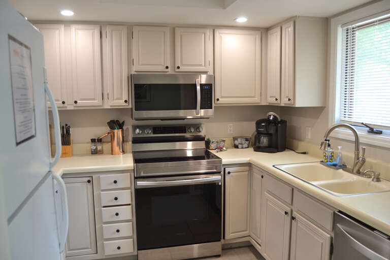 You'll love preparing meals in this bright, fully equipped kitchen with modern stainless appliances, ample counter space, and classic white cabinetry perfect for your home-away-from-home cooking adventures.